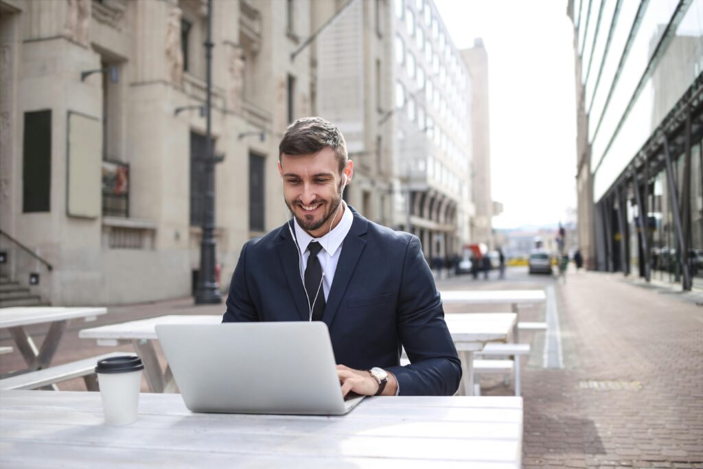 pexels-photo-3777559-3777559 Professional man enjoying remote work on a laptop outdoors in a city setting.